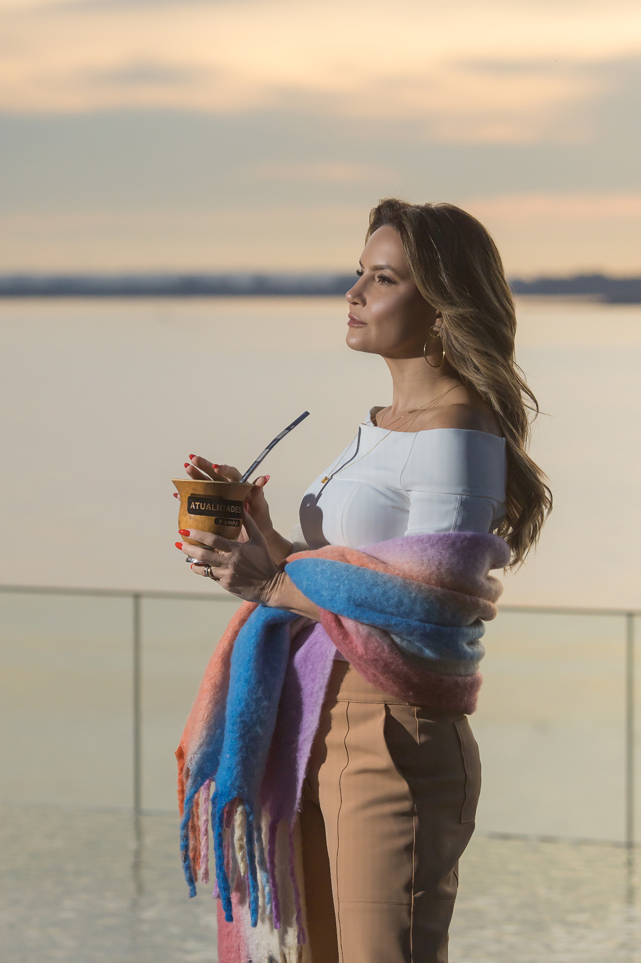Ali Klemt contemplativa ao pôr do sol, com cuia de mate da TV Pampa